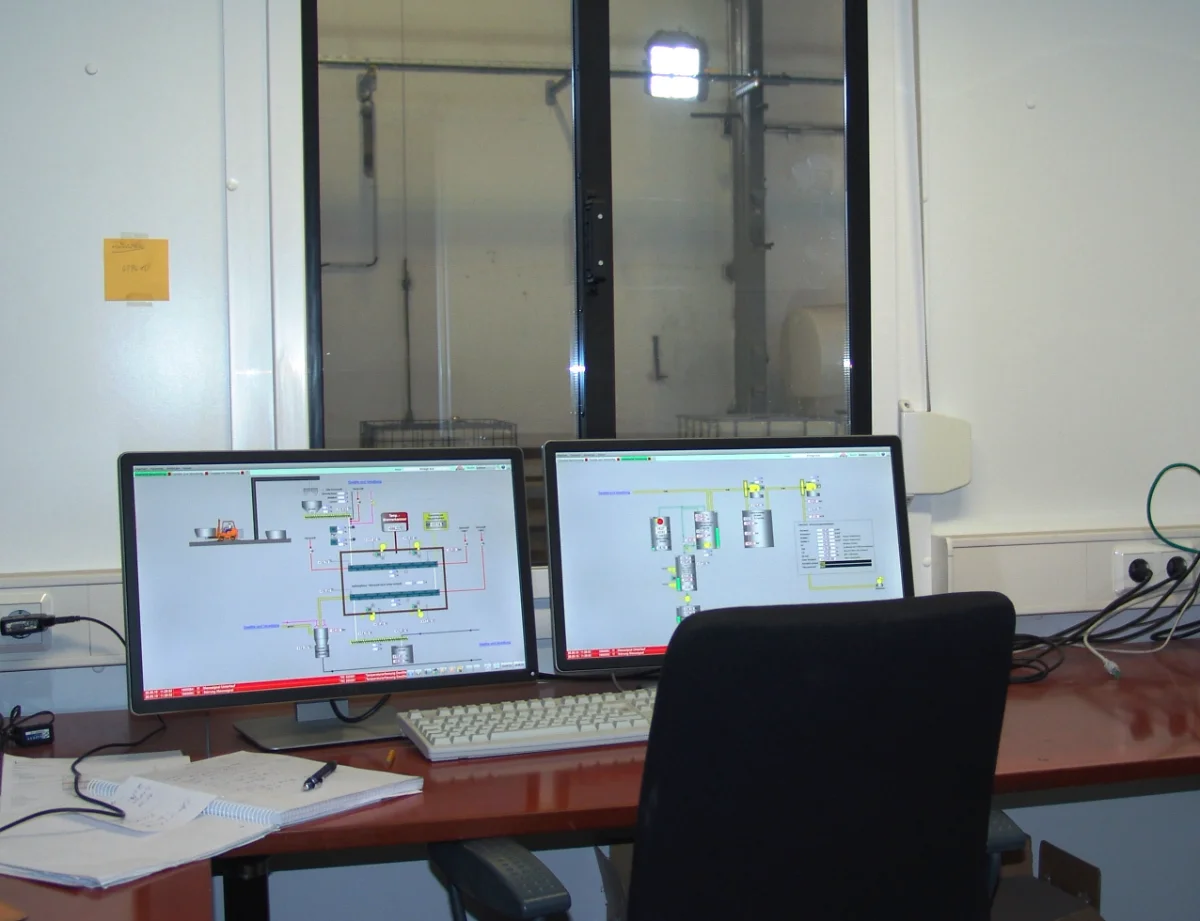 Control room of the Innovation and Research Center in Guben with process diagrams on two monitors